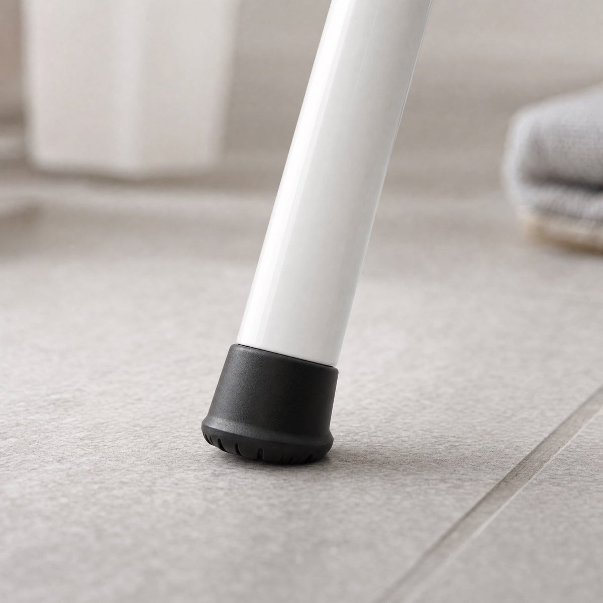 Non-slip rubber foot cap gripping a bathroom tile